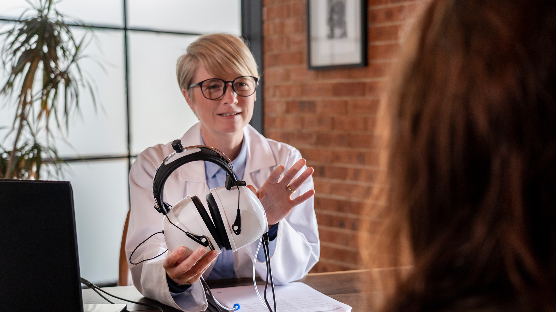 Audiologist reviewing audiometric equipment with a patient
